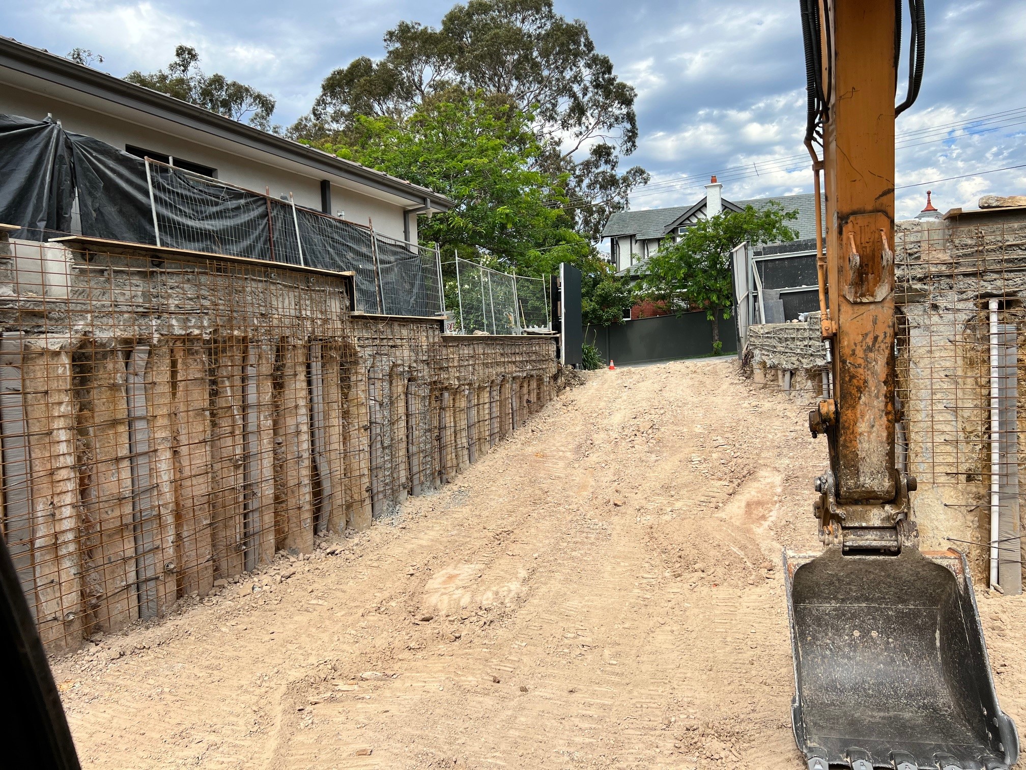 Bulk excavation with ramp grade showing sheet piling and retaining walls